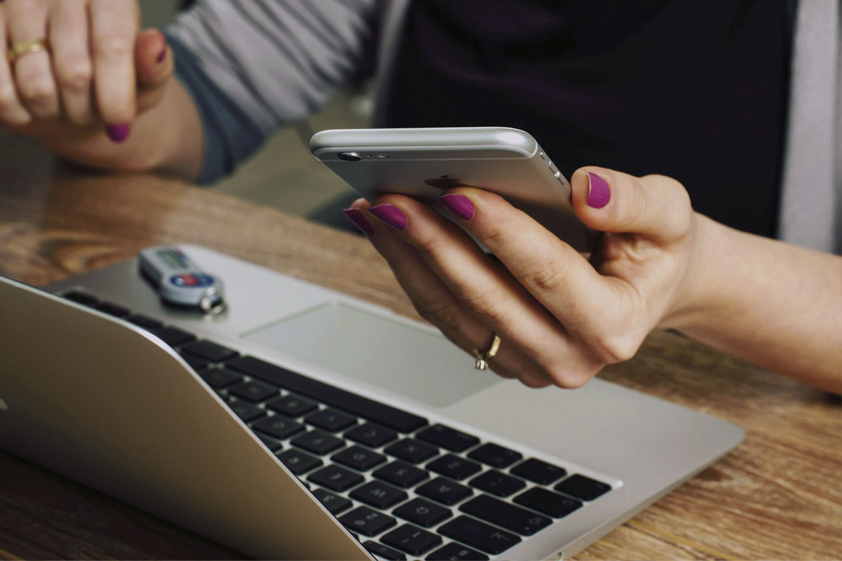Woman sitting with laptop and smartphone